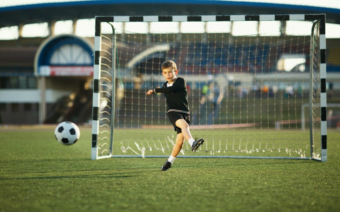 Little boy plays football